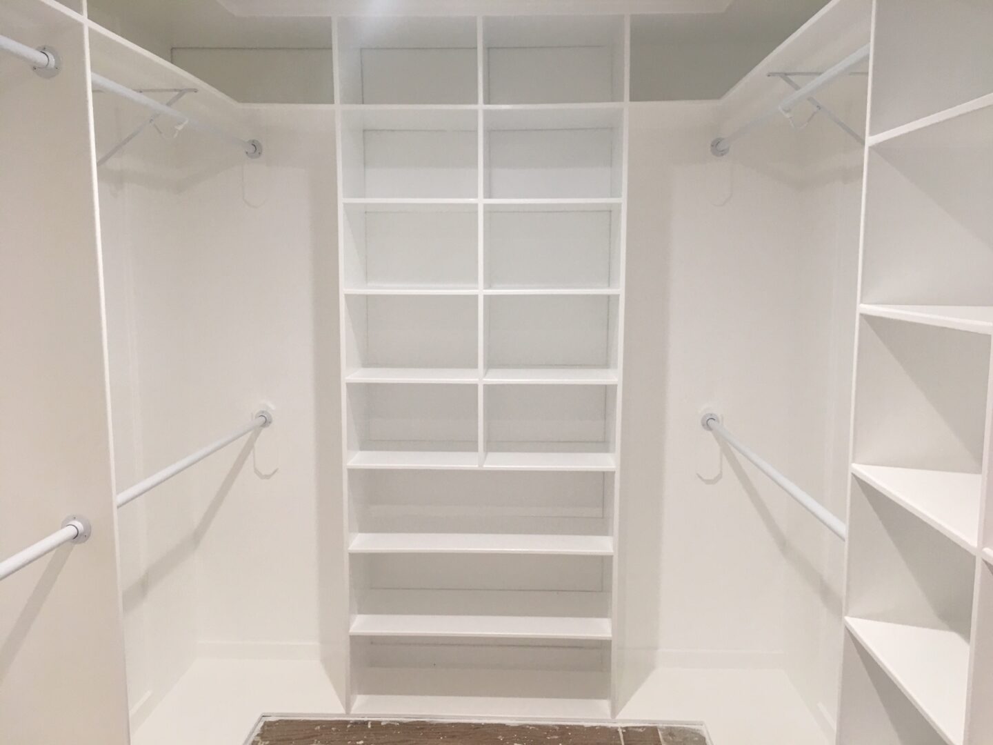 A white closet with shelves and stairs in it