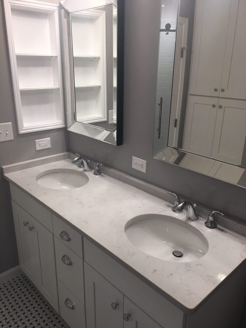 A bathroom with two sinks and a mirror.