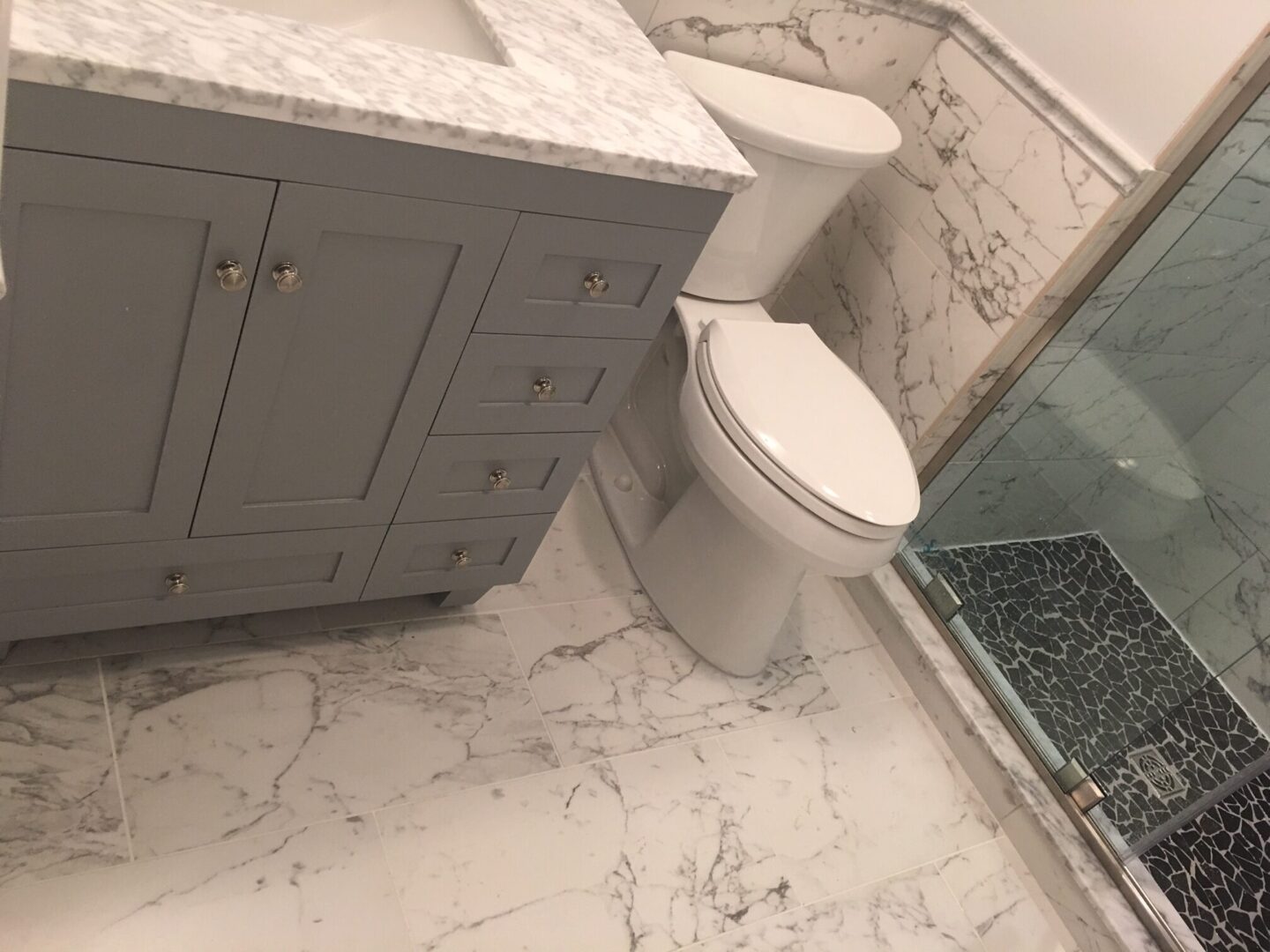 A bathroom with marble floors and walls.