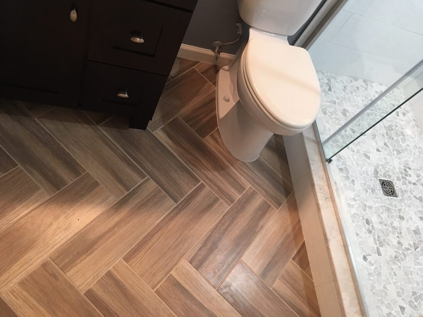 A bathroom with wood floors and white toilet.