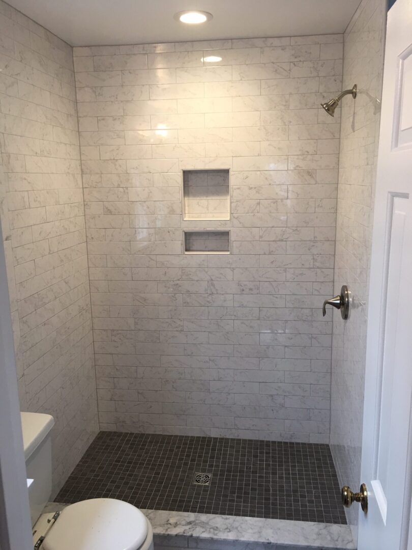 A bathroom with a shower and tiled walls.