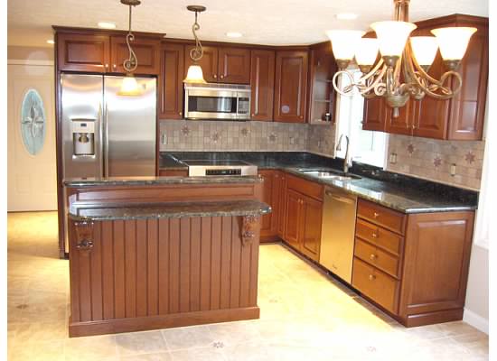 A kitchen with wooden cabinets and black counter tops.