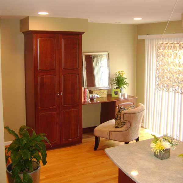 A living room with a large wooden cabinet and a chair.