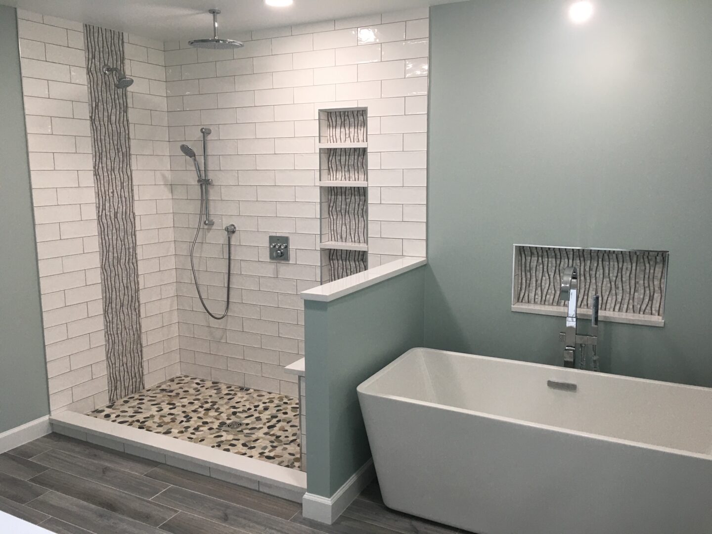 A bathroom with a tub, shower and tiled walls.