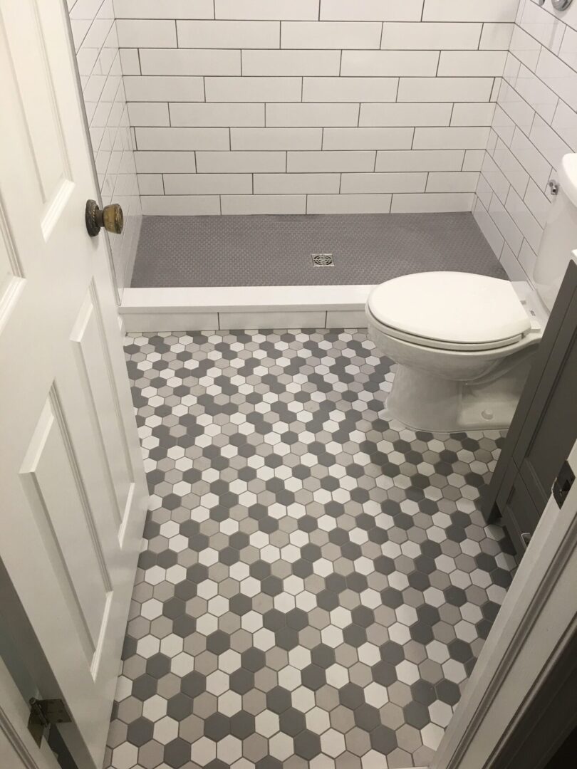 A bathroom with a toilet and tiled floor